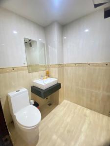 a bathroom with a white toilet and a sink at Khách sạn Hoàng Hải in Ho Chi Minh City