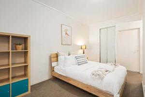 a bedroom with a large bed with white sheets at A Comfortable Studio Near Darling Harbour in Sydney