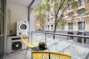 a balcony with a table and chairs and a washing machine at A Comfortable Studio Near Darling Harbour in Sydney