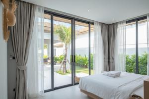 a bedroom with a bed and a large window at Mouana Breeze Mai Khao VIP 4-bedroom Pool Villa 9911 in Phuket +57 photos