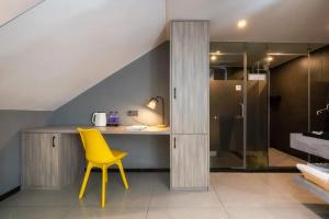 una sedia gialla in un bagno con doccia di Yangshuo EMOJI YOUTH HOSTEL a Yangshuo