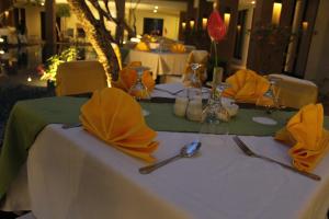 stół z żółtymi serwetkami i przyborami kuchennymi w obiekcie Hotel Santika Kuta w mieście Kuta