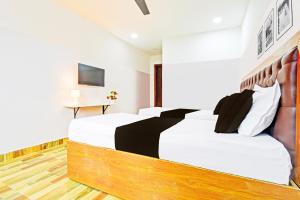 a bedroom with a large bed with black and white pillows at Hotel O Stayo Inn in Hyderabad