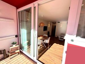 a room with a balcony with a table and a glass door at Brisa Marina Stay a unos pasos del mar in Valencia