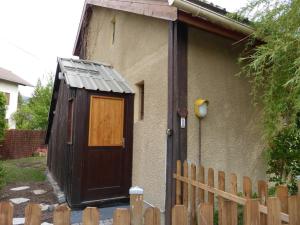 una piccola casa con una porta in legno accanto a una recinzione di Chalet confortable 45 m², 5 couchages avec jardin à Barcelonnette - FR-1-804-54 a Barcelonnette