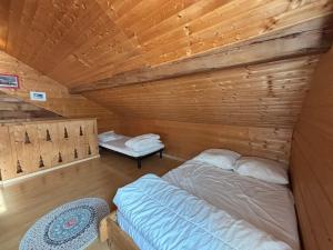 Cette chambre comprend un lit dans une cabane en bois. dans l'établissement Chalet confortable à Méaudre pour 8 pers, vue imprenable - FR-1-737-98, à Méaudre 4 autres photos