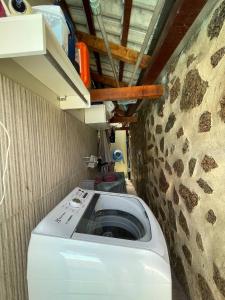 lavadora en una habitación con pared de piedra en Smart Suíte, en Boa Vista