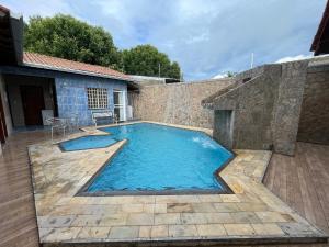 Una piscina en un patio trasero con una pared de ladrillos. en Smart Suíte, en Boa Vista 5 fotos más