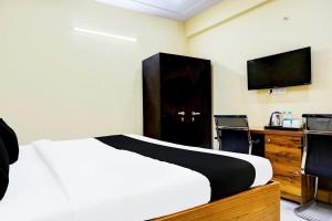 a bedroom with a bed and a desk and a television at Hotel O Mother Touch in Indirapuram