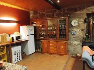 a kitchen with a white refrigerator and a counter at Village Minhoure in Felgueiras