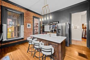 a kitchen with a bar with stools and a refrigerator at Charming 7BR Home Bourbon Trail & Attractions in Louisville +202 photos