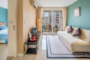 un salon avec un canapé et une fenêtre dans l'établissement Grande Caribbean Condo Resort one-bedroom near Walking street and Jomtien Beach, à Pattaya (sud) 27 autres photos