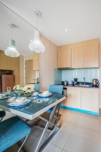 une cuisine avec une table à manger et des chaises bleues dans l'établissement Grande Caribbean Condo Resort one-bedroom near Walking street and Jomtien Beach, à Pattaya (sud)