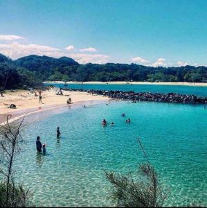 a group of people in the water at a beach at One Fabulous Room Brunswick Heads in Brunswick Heads +14 photos