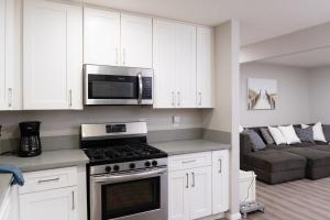 サンディエゴにあるCentral San Diego 3BR Home Near Beachesのコンロ、電子レンジ、ソファのあるキッチン