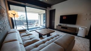 a living room with a couch and a television at Mayu Futahari in Nishiizu +81 photos