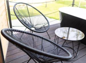 ein Paar Stühle und Tische auf einer Veranda in der Unterkunft Halicanum Glamping Peaceful Retreat Resort in Sveti Martin na Muri