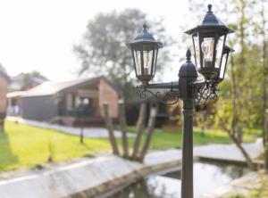 ein Straßenlicht mit einem Haus im Hintergrund in der Unterkunft Halicanum Glamping Peaceful Retreat Resort in Sveti Martin na Muri