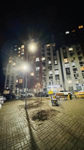 a park with a bench and a street light at night at Alatau city 1 room in Almaty