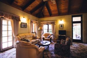 un soggiorno con divani, tavolo e finestre di Holberry House a Nannup