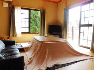 ein Wohnzimmer mit einem Tisch und einem Laken darauf in der Unterkunft Chalet 別邸しろうま in Hakuba