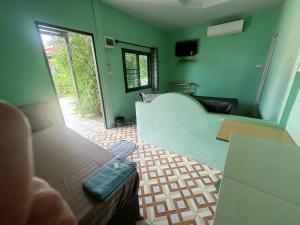 a living room with a couch and a room with a window at บางกะโดรีสอร์ท Bangkado Resort in Ban Bang Krado