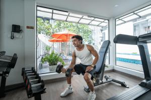 a man sitting on a treadmill in a gym at Citrus Patong Hotel by Compass Hospitality in Patong Beach