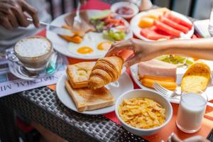 a table full of breakfast food with eggs and toast at Citrus Patong Hotel by Compass Hospitality in Patong Beach