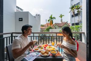 a man and woman sitting at a table eating food at Citrus Patong Hotel by Compass Hospitality in Patong Beach +34 photos