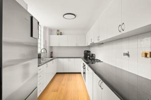 Η κουζίνα ή μικρή κουζίνα στο Spacious 2-Bed Apartment Near Parramatta CBD