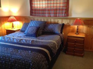 BallandeanにあるFergies Hill Spa Cottage @ Granite Ridge Winesのベッドルーム1室(ベッド1台、テーブルにランプ2つ付)