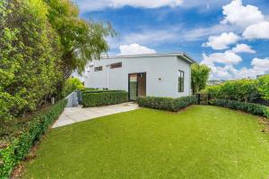 a white house with a green yard at The Moorings Apartment 6 - Close to the Lake! in Taupo