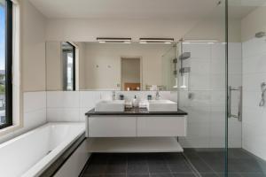 a bathroom with two sinks and a tub and a mirror at The Moorings Apartment 6 - Close to the Lake! in Taupo +27 photos