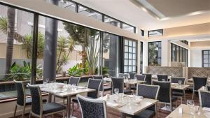 a restaurant with tables and chairs and large windows at Comfortable Hotel Studio at Legends Resort - CoastHM in Gold Coast