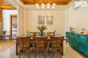 Una cocina y un comedor con mesa y sillas. en StayVista at Chestnut Manor with Lawn, BBQ, Bonfire, en Kasauli