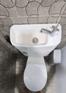 a bathroom with a white toilet and a sink at Budget Traveler Only Home in Legazpi +34 photos