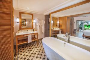 un bagno con vasca, 2 lavandini e un letto di Sugar Beach Mauritius a Flic-en-Flac