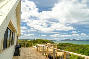 a balcony of a house with a view of the ocean at Nine Mile House in Swansea