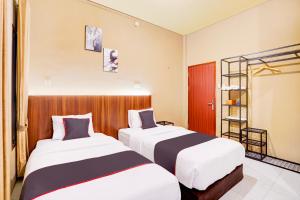 a hotel room with two beds and a ladder at Collection O Padang City Center Near Transmart Padang Formerly De Orchids in Padang