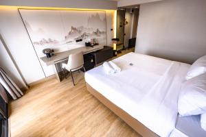 a bedroom with a large white bed and a desk at Near Don Mueang Hotel in Bangkok