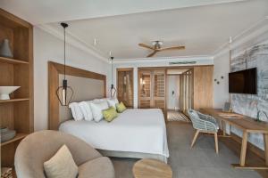 una camera da letto con un grande letto bianco e una scrivania di Sugar Beach Mauritius a Flic-en-Flac