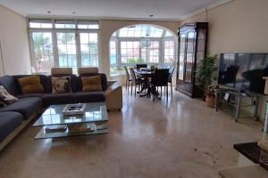 a living room with a couch and a table at Casa primera línea vistas al mar con Parking in La Venteta