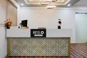 an office with a reception desk with a sign on it at Super Hotel O VIP Road formerly Hotel Lotus in Surat