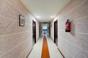 a hallway with a fire extinguisher on the wall at Super Collection O Awas Vikas Near Bus Stand Formerly Hotel Rivera in Rudrapur