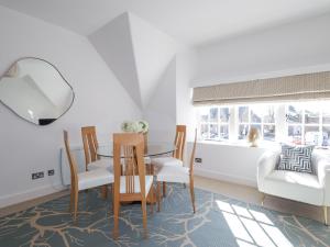 a dining room with a table and chairs and a couch at Aspen Spa Apartment in Dornoch +24 photos