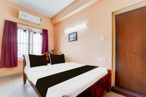 un dormitorio con una cama grande en una habitación en Super Hotel O Anna Nagar Madurai, en Madurai