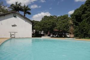 a swimming pool in front of a white building at Casa estilo colonial in Pedra de Guaratiba