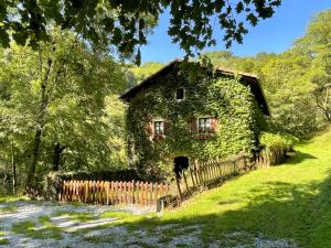 an old house covered in green ivy next to a fence at Casa rural Garata in Arantza