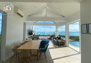 a dining room with a table and chairs at Villa V4 IDYLLIC - Stunning Seaview in Ban Bang Po