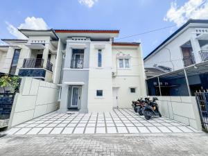 deux motocycles garés devant un bâtiment blanc dans l'établissement Villa Pesona Palagan, à Beran-kidul